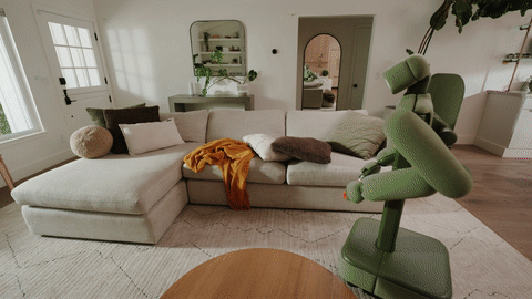 Animation: Isaac bewegt am Sofa beide Arme, um eine Decke zu ordnen