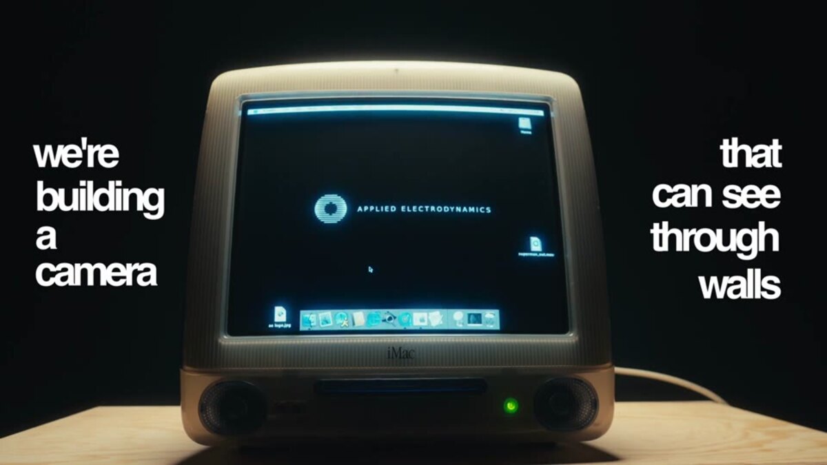 Bildschirm eines alten Computers im Dunkeln mit dem Satz, dass hier eine Kamera gebaut wird, die durch Wände sehen kann