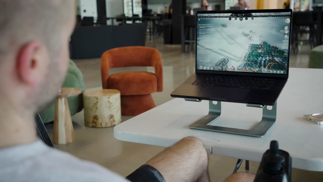 Studienteilnehmer sitzt vor einem Laptop mit einer Strategie-Software auf dem Bildschirm